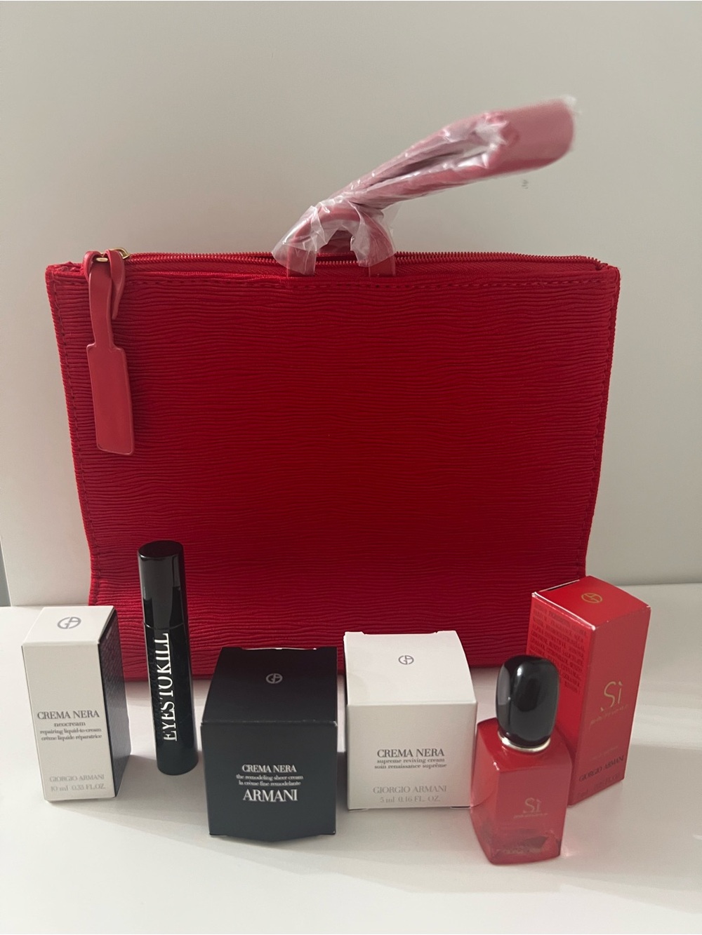 Red Textured Cosmetic Pouch with 5 mini samples.